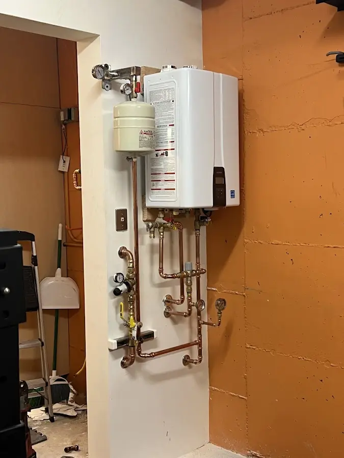 Plumbing technician inspecting water heater connections in Boylston